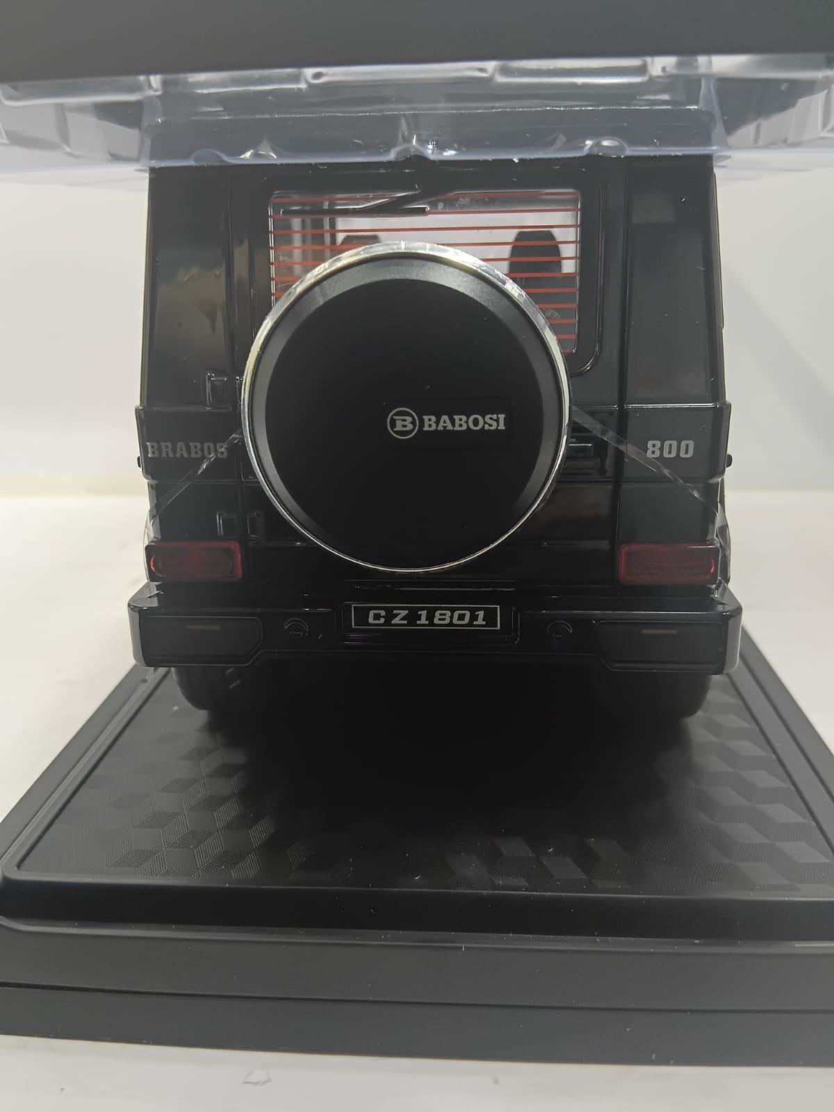 A black diecast model car of a Mercedes-Benz G-Class, specifically a GZ 1801, shown from the rear. It features a circular spare tire cover with the 'BABOSI' logo, silver trim, and 'BRABOS' and '800' markings on the sides.